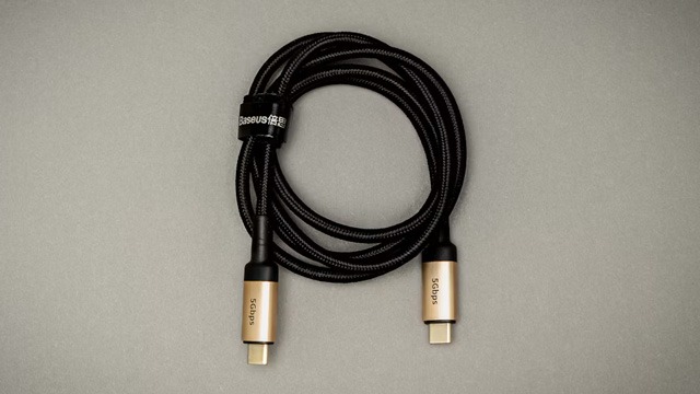 Fekete USB-C kábel fehér felületen, közelről fényképezve.